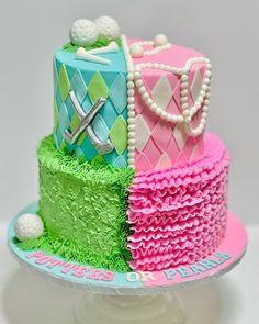 a three tiered cake decorated with pink, green and blue icing