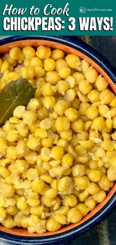 a bowl filled with chickpeas next to a green leaf