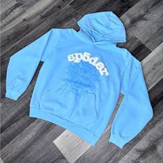 Brand New Size M Blue Glitter Sweater, Blue Sp5der Hoodie, Blue Hoodie With Drawstring For Streetwear, Light Blue Sporty Sweatshirt For Streetwear, Sporty Light Blue Sweatshirt For Streetwear, Blue Hooded Sweatshirt For Streetwear, Light Blue Graphic Print Sweatshirt For Winter, Winter Light Blue Graphic Sweatshirt, Blue Graphic Print Hoodie For Fall