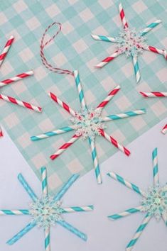 paper straw snowflakes and candy canes on a blue checkered tablecloth