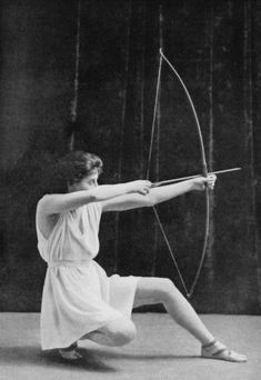 an old photo of a woman with a bow and arrow in the middle of her body