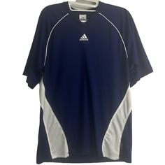 an adidas shirt hanging on a hanger in front of a white wall and floor