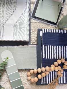 the table is covered with different types of fabric and wood bead necklaces on it