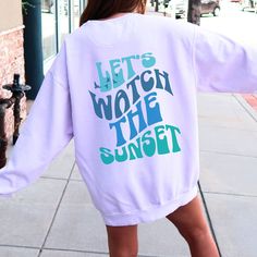 "Let'S Watch The Sunset Shirt | Summer Hoodie | Lets Watch The Sunset Shirt | Beach Lover Shirt | Let'S Watch The Sunset Hoodie Beach Sweatshirts: https://etsy.me/3pdRnVI Beach Shirts:  https://etsy.me/3yYlNg9GgbDf8 OUR SIZING IS ADULT UNISEX. This means it will be larger than normal women's sizing.  Please see photos for size charts 🌻 Please read the full description:   This hoodie/sweatshirt sizing is NOT oversized.  You need to order at least 1-2 sizes larger for the extra baggy look in this photo.  (The normal sizing is UNISEX.) 🔔 Example: if you use size S choose between a size L or XL.  💡 HOW TO PLACE YOUR ORDER: 1. Please Check and Review all the Photos 2. Select your Shirt Color and Size from drop down menu 3. Choose your Quantity as much as you want 4. Click \"Add To Cart\". Yo Vsco Style Sweatshirt With Letter Print For Vacation, Vsco Crew Neck Sweatshirt With Letter Print, Vsco Style Long Sleeve Sweatshirt For Vacation, Pink Letter Print Sweatshirt For Vacation, Summer Long Sleeve Sweatshirt With Text Print, Trendy Summer Sweatshirt With Text Print, Trendy Summer Sweatshirt With Letter Print, Oversized Letter Print Sweatshirt For Summer, Trendy Graphic Print Sweatshirt For Vacation