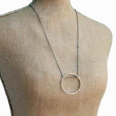 This chic sterling silver hoop necklace is equally lovely with jeans or a little black dress. The oxidized sterling silver chain holds an organic circle of sterling silver. With its modern style and pure grace, the Full Circle Necklace will hardly get a moment's rest. It is artisan-crafted and 27" long. Layer it with our Raise the Bar Necklace. Style # N370 Sterling silver 27" long Lobster Clasp ".925" sterling silver quality stamp Interlocking Circles Silver Necklace, Luxury Full Circle Sterling Silver Jewelry, Long Layer, Hoop Necklace, Raise The Bar, A Little Black Dress, Roman Glass, Scene Design, Circle Necklace