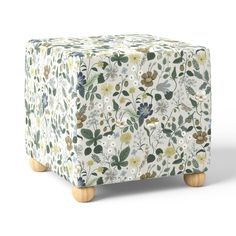 an ottoman cover with flowers and leaves on it, sitting in front of a white background