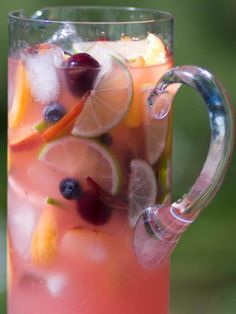 a pitcher filled with fruit and ice on top of a table