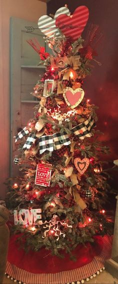 a christmas tree decorated with red, white and black ribbon hearts is shown in this image