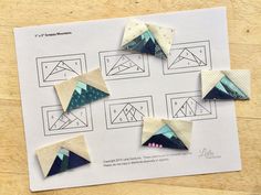 four pieces of paper are placed on top of a piece of paper that has been cut into triangles