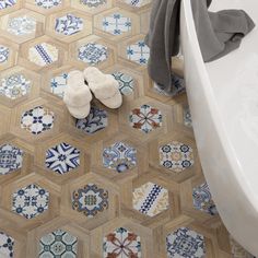 a pair of slippers sitting on the floor next to a bathtub