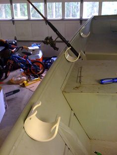 the inside of a garage with tools and other items on the floor, including a fishing rod