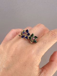 ♥ 14K Gold Vintage Ring with Three Blue Green Enamel Flowers with Ruby Center 7.11g R6734♥ The item measures 13.4mm in length (North South direction), 26mm in width (East West direction), and stands 7.3mm tall from the finger. Band width is 4mm. ♥ US size 8 (Free resizing up or down 1 size)♥ Material: 14K Gold ~ 7.11g♥ Gemstone: Ruby ♥ Note: This is a preowned piece that may have signs of wear and tear, and minor discoloration due to its age. This piece may or may not have been polished or sized Blue Enamel Ring In Fine Jewelry Style, Blue Enamel Ring Fine Jewelry, Blue Enamel Fine Jewelry Ring, Blue Enamel Ring With Gemstone In Fine Jewelry Style, Blue Enamel Ring With Gemstone Fine Jewelry, Blue Enamel Ring With Gemstone, Fine Jewelry Enamel Multi-stone Ring Gift, Enamel Multi-stone Rings As A Gift, Blue Enamel Ring With Gemstone For Gift