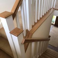 a wooden banister next to a white stair case