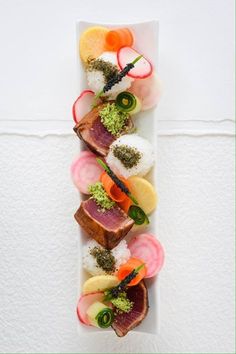 a white plate topped with lots of different types of sushi on top of it