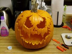 a carved pumpkin sitting on top of a wooden table