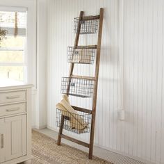 a ladder leaning against the wall with baskets on it