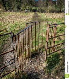 an old iron gate in the middle of a field