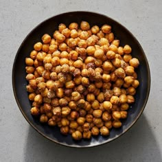 a black bowl filled with chickpeas sitting on top of a gray countertop