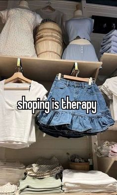 there is a rack with shirts and skirts on it that says, shopping is therapy