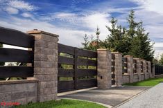 a stone fence with wooden posts on the side