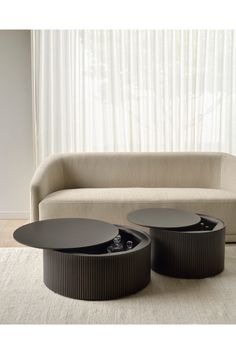 two coffee tables sitting in front of a couch