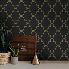 a potted plant sitting on top of a table next to a wallpapered wall