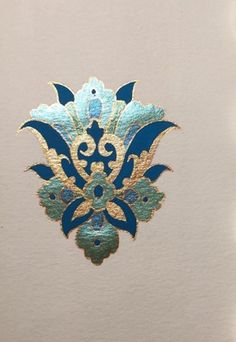 an ornate blue and gold design on white paper