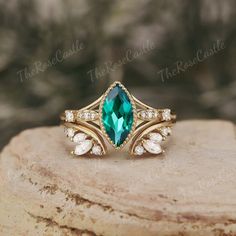 a close up of a ring on top of a rock with green and white stones