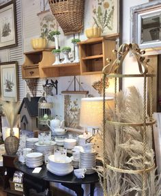 a room filled with lots of white dishes and vases on top of wooden shelves