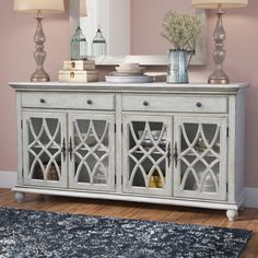 a white sideboard with glass doors in a living room