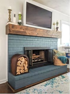 a fireplace with logs and a flat screen tv above it