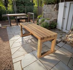 a wooden bench sitting on top of a stone patio