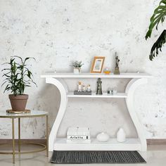 a white shelf sitting next to a potted plant on top of a wooden table