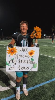 a young man holding a sign that says, will you be my sunshine at hope?