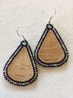 wooden and beaded tear earrings on white background, close up view with clippings