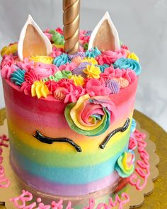 a birthday cake decorated with an unicorn's horn and flowers