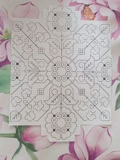 two cross stitch designs on top of each other with pink flowers in the back ground