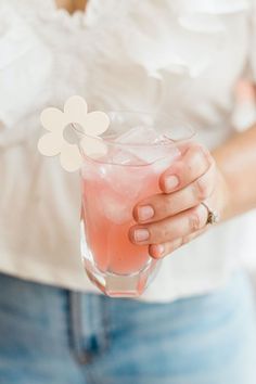 a close up of a person holding a drink with a flower on the top of it