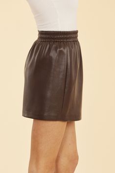 A classic example of the perfect fall skirt, our Faux Leather Mini Skirt with Elastic Waistband adds an edgy touch to any outfit. Crafted from premium faux leather, this mini skirt features a comfortable elastic waistband for a flattering fit that moves with you. Pair it with a blouse and heels or dress it down with a cozy sweater, tights, and ankle boots. Faux leather Mini length Elastic waistband Available in Coffee and Black Dry clean Style: 75509 Fall Mini Skirt With Elastic Waistband In Relaxed Fit, Relaxed Mini Skirt With Elastic Waistband For Fall, Sleek Faux Leather Mini Skirt For Fall, Chic Short Mini Skirt For Fall, Sleek Leather Mini Skirt For Fall, Elastic Waistband Mini Skirt For Work, Leather Pencil Mini Skirt For Fall, Workwear Mini Skirt With Elastic Waistband, Leather Mini Bottoms For Fall