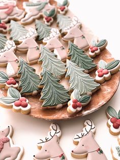 decorated christmas cookies on a platter with reindeers and holly tree decorations in the shape of trees