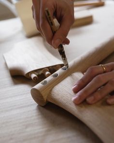 a person is making something out of wood and glues it with a wooden stick