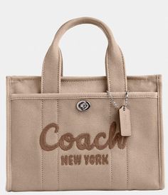 From COACH&#x2C; the Small Cargo Tote 26 Bag features:Canvas&#x2C; grosgrain&#x2C; and recycled leatherZip-top closureFabric liningHandles with 4" dropOutside turn-lock and snap pocketsDetachable strap with 24" drop for shoulder or crossbody wearFits an iPadApprox.: 10.25" L x 7.75" H x 5" WImported. Cuddle Season, Baggage Claim, Coach Tote Bags, Embroidered Canvas, Coach Logo, Coach New York, Coach Tote, Small Tote Bag, Bags Aesthetic