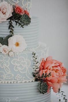 a three tiered cake with flowers on top