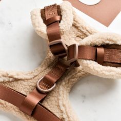 a pair of brown sandals sitting on top of a white counter next to a tag