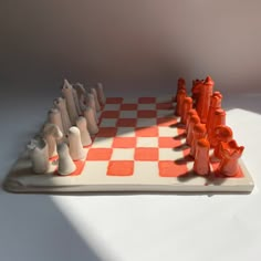 an orange and white chess board with pieces on it