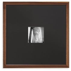 a black and white photo hanging on a wall next to a wooden framed artwork piece