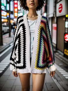 a woman is walking down the street wearing a crochet sweater and shorts with her hair in an afro hairstyle