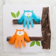 two paper owls sitting on top of a tree branch