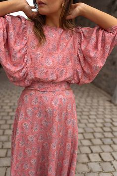 Perfect for dressing up or dressing down, our pink, paisley-patterned Karlou blouse is the ultimate summer wardrobe staple. Featuring a crewneck, a drawstring to tie on back, and 7/8th length balloon sleeves, this blouse is slightly cropped and totally adorable. Our model is also wearing the Larou skirt and Maddie jeans One size (fits from US 2-4-6-8) Length 18.5 in - Width 13.78 in 100% viscose Washing: handwash only Summer Crew Neck Top With Gathered Sleeves, Crew Neck Top With Gathered Sleeves For Summer, Casual Tops With Bishop Sleeves For Summer, Casual Bishop Sleeve Tops For Summer, Spring Pink Puff Sleeve Top With Gathered Sleeves, Pink Bishop Sleeve Blouse For Spring, Chic Pink Blouse With Gathered Sleeves, Pink Long Sleeve Blouse With Gathered Sleeves, Pink Blouse With Gathered Sleeves For Fall