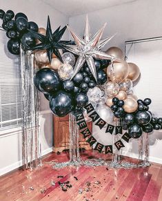 black and gold balloons are arranged in the shape of an arch with stars on it